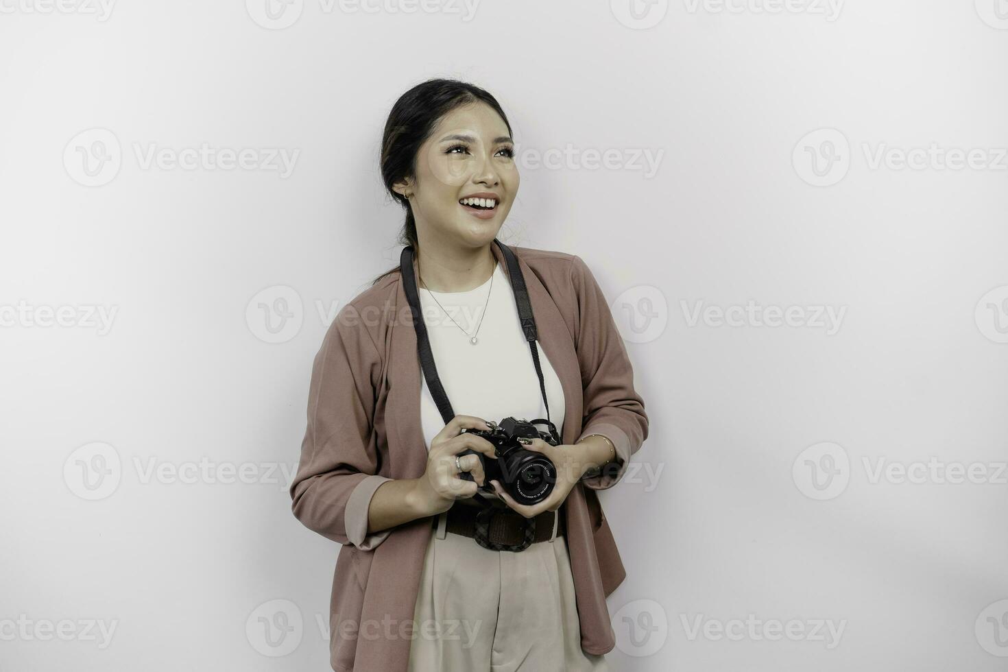 allegro giovane asiatico donna turista in piedi con telecamera assunzione foto isolato su bianca studio sfondo