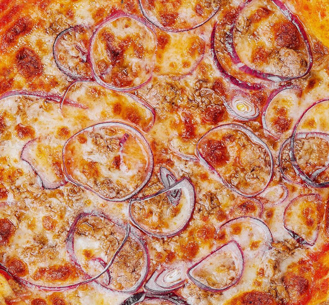 Pizza con tonno e rosso cipolla su di legno taglio tavola foto