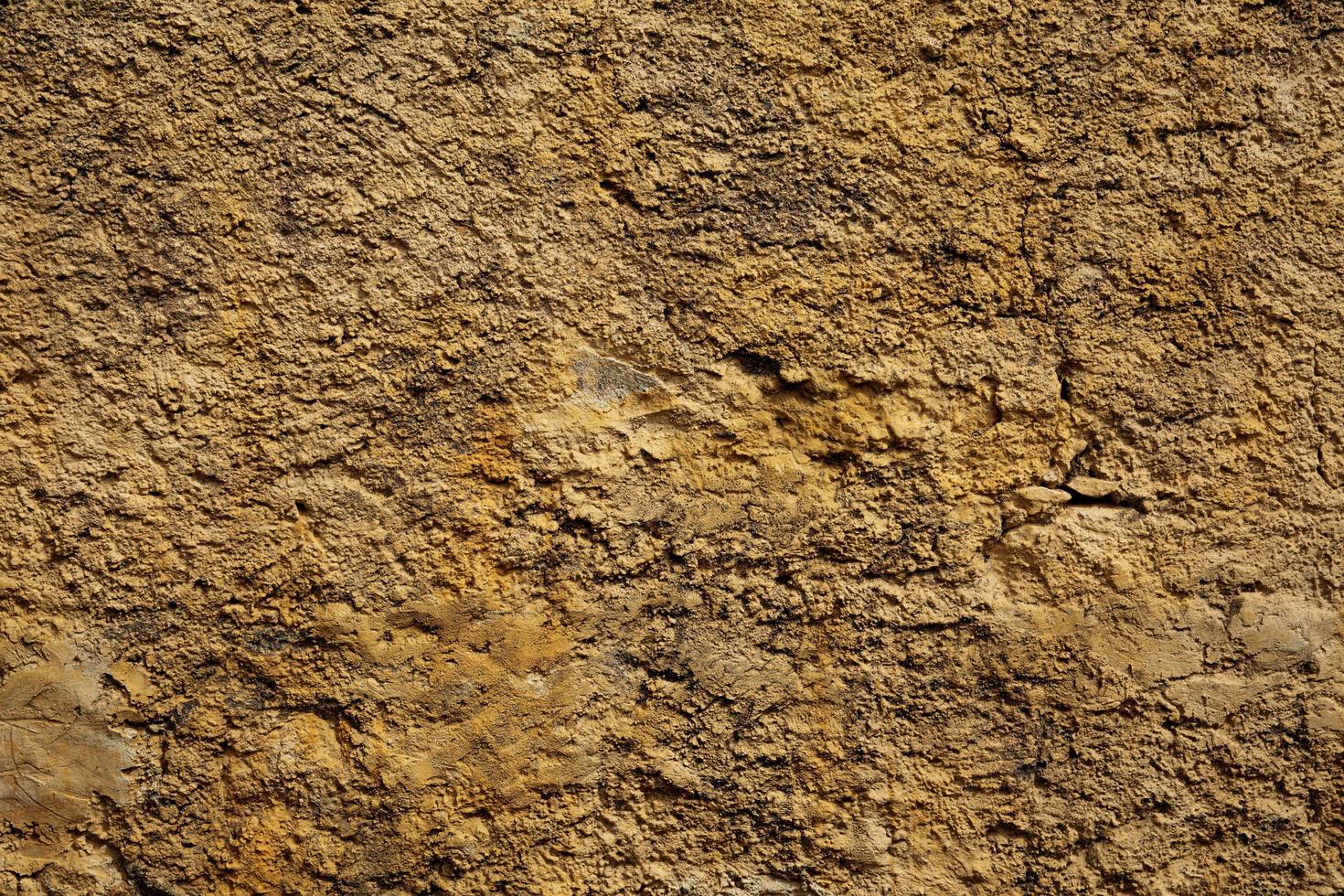 muro di pietra giallo in piccole crepe foto