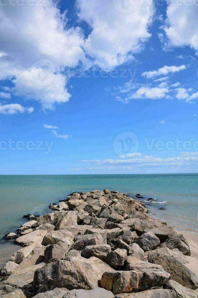 un' roccioso litorale con un' blu cielo e nuvole foto