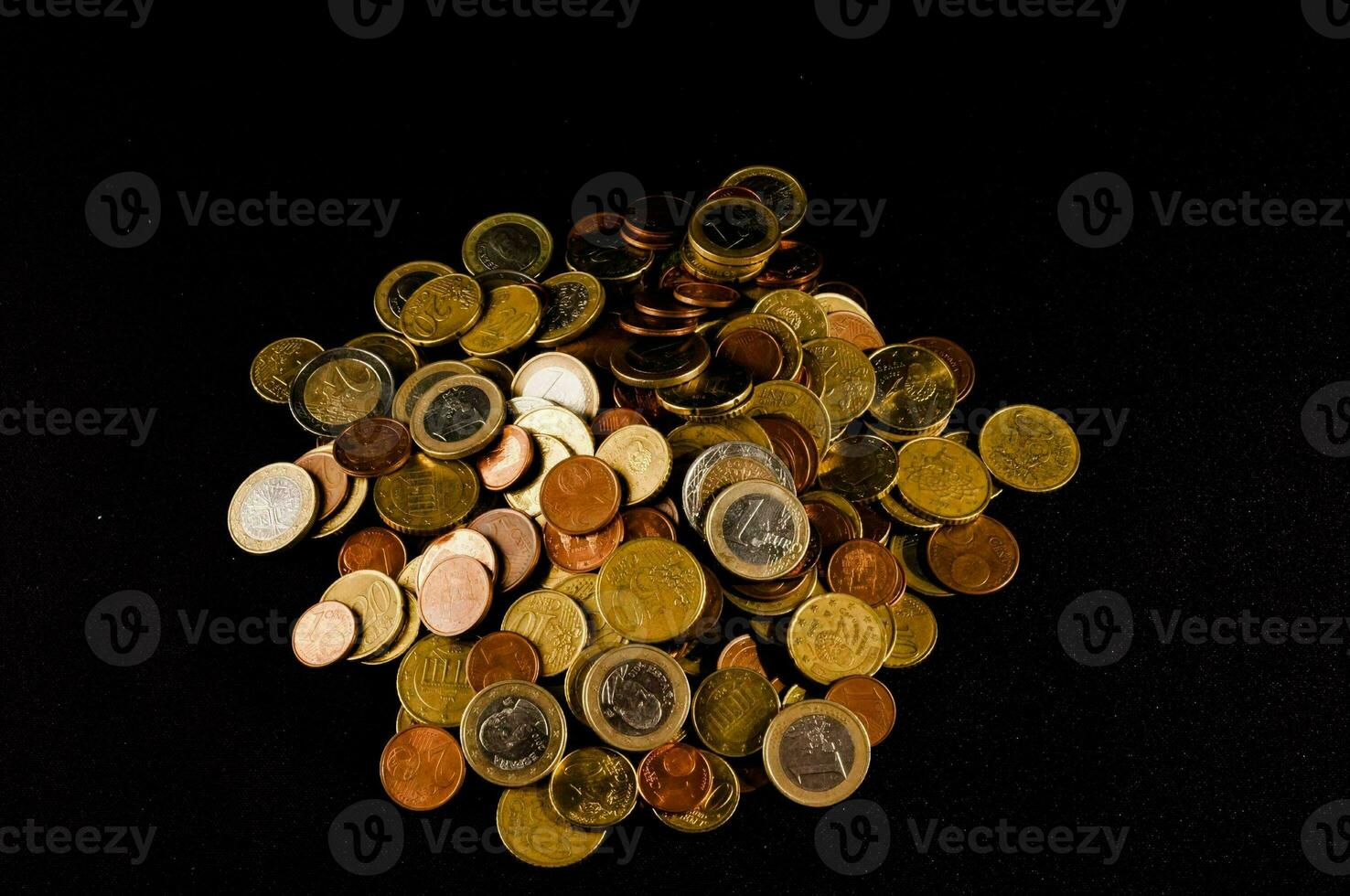 un' mucchio di monete su un' nero sfondo foto
