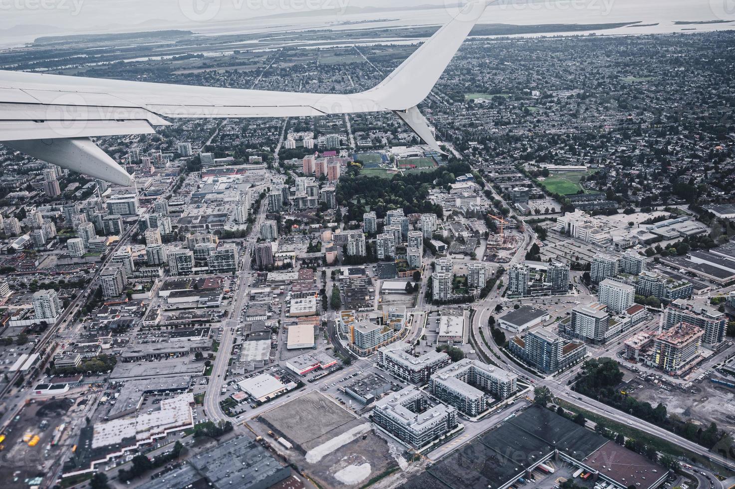 vista aerea dell'ala dell'aeroplano sul traffico in una città affollata foto