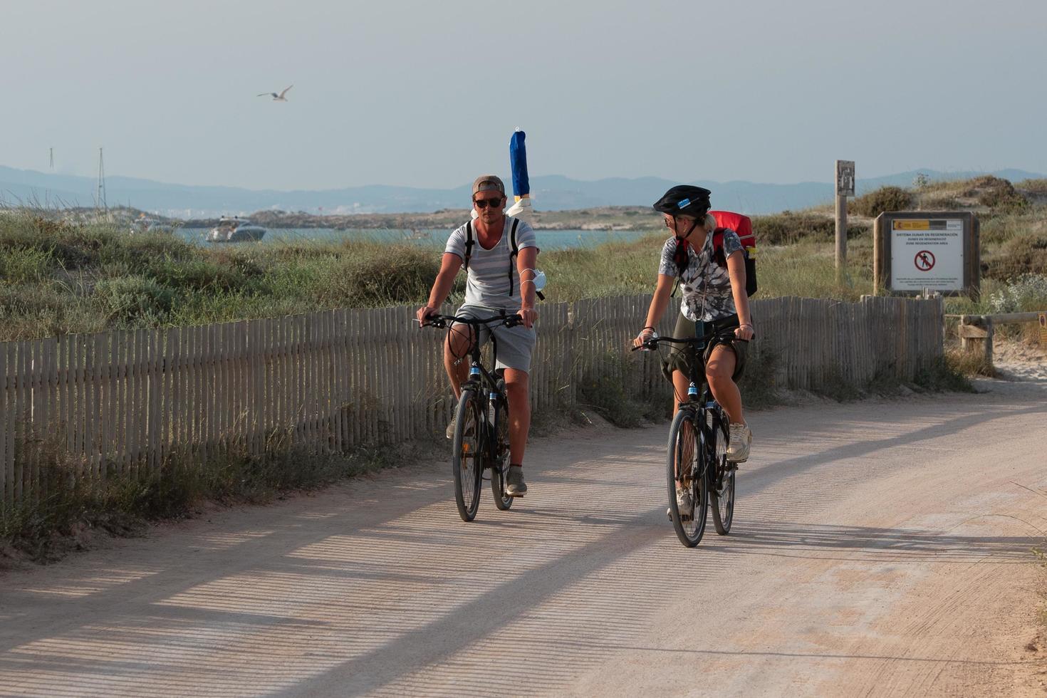 turisti in bicicletta sulla spiaggia di illetes a formentera in spagna 2019 foto