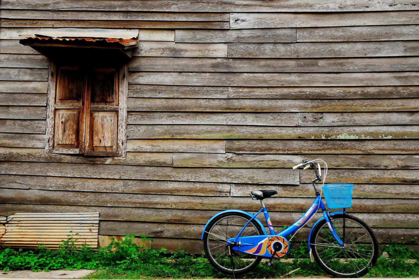 muri, vecchie case di legno e una bici blu foto