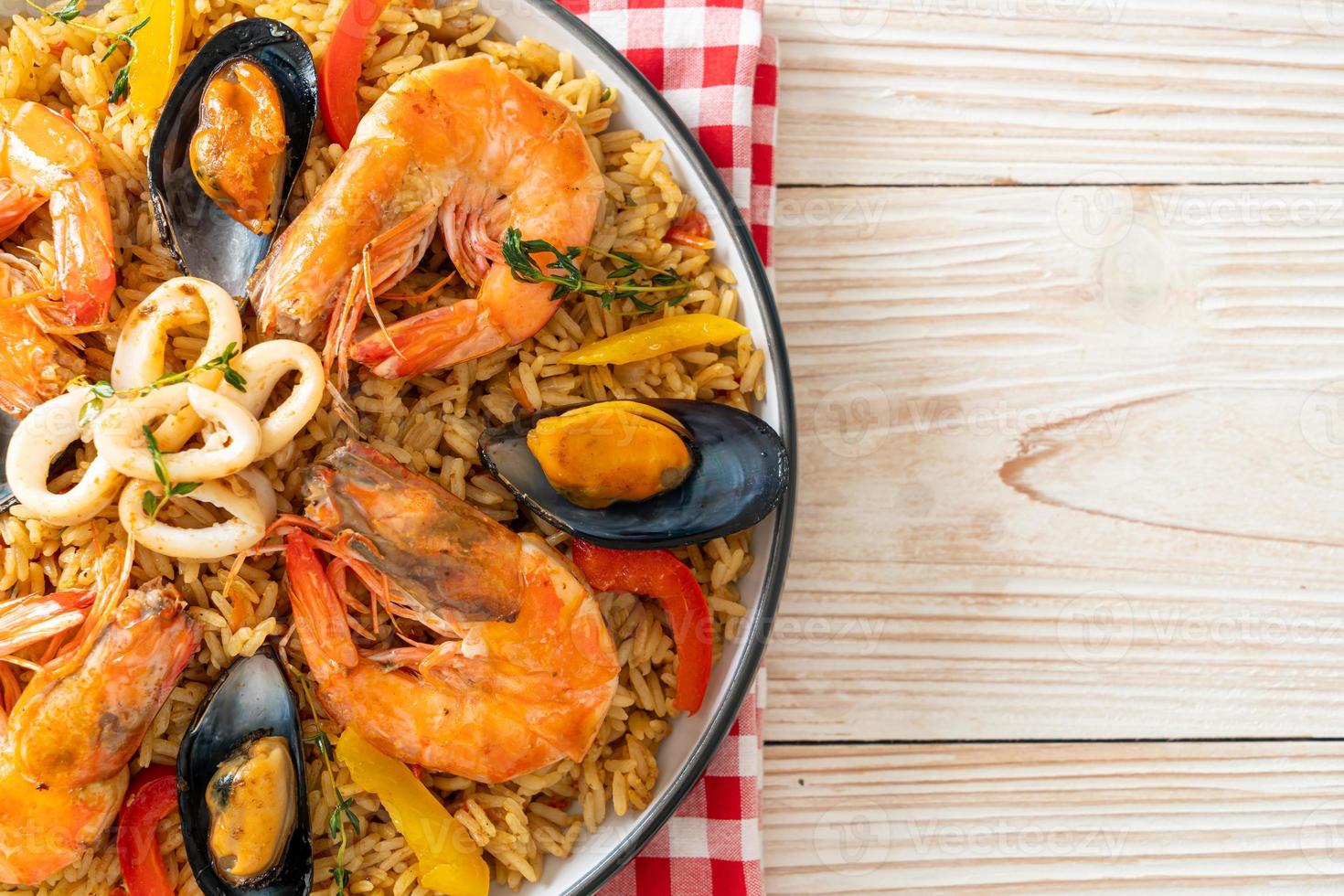 paella di mare con gamberi, vongole, cozze su riso allo zafferano foto