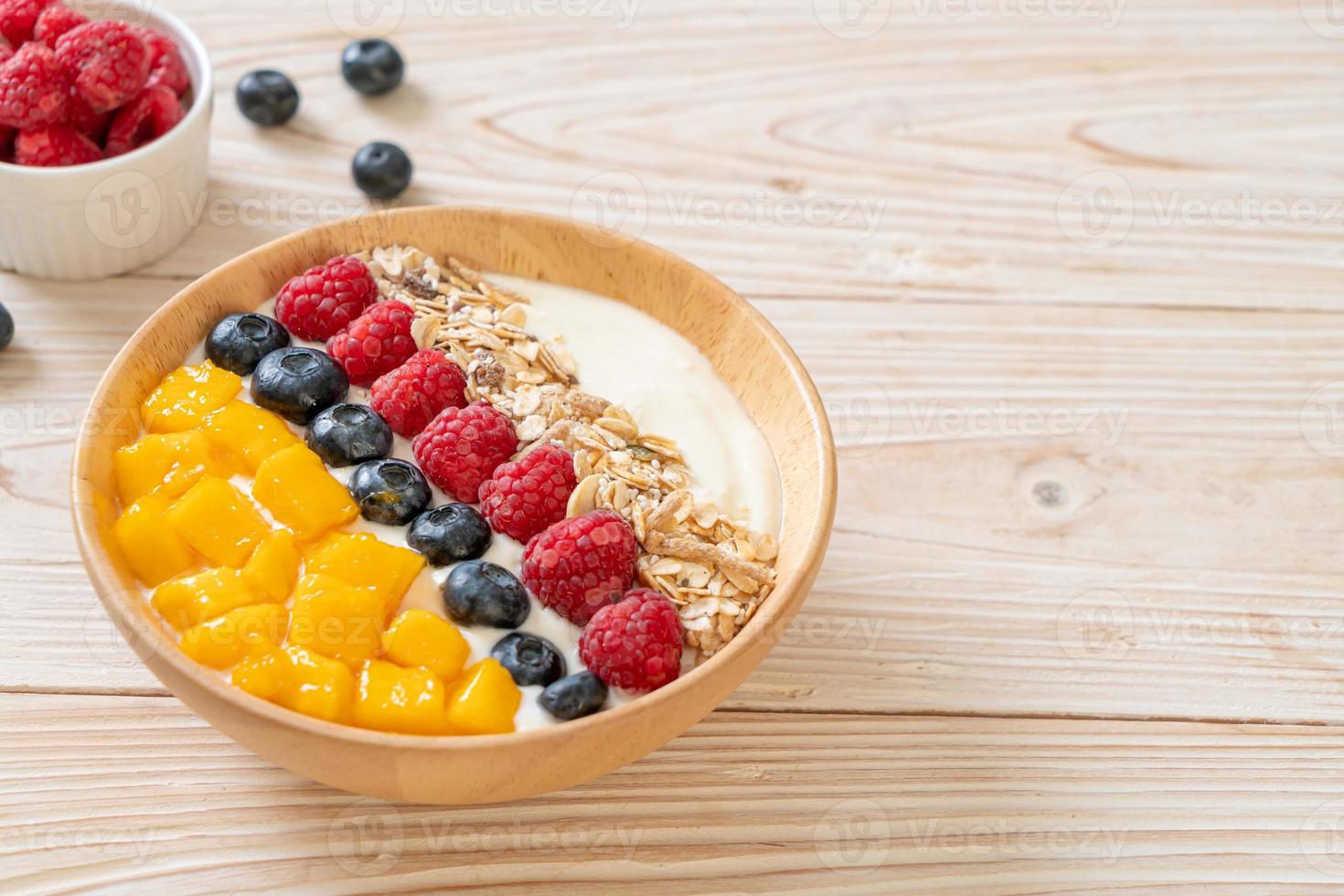 ciotola di yogurt fatta in casa con lampone, mirtillo, mango e muesli foto