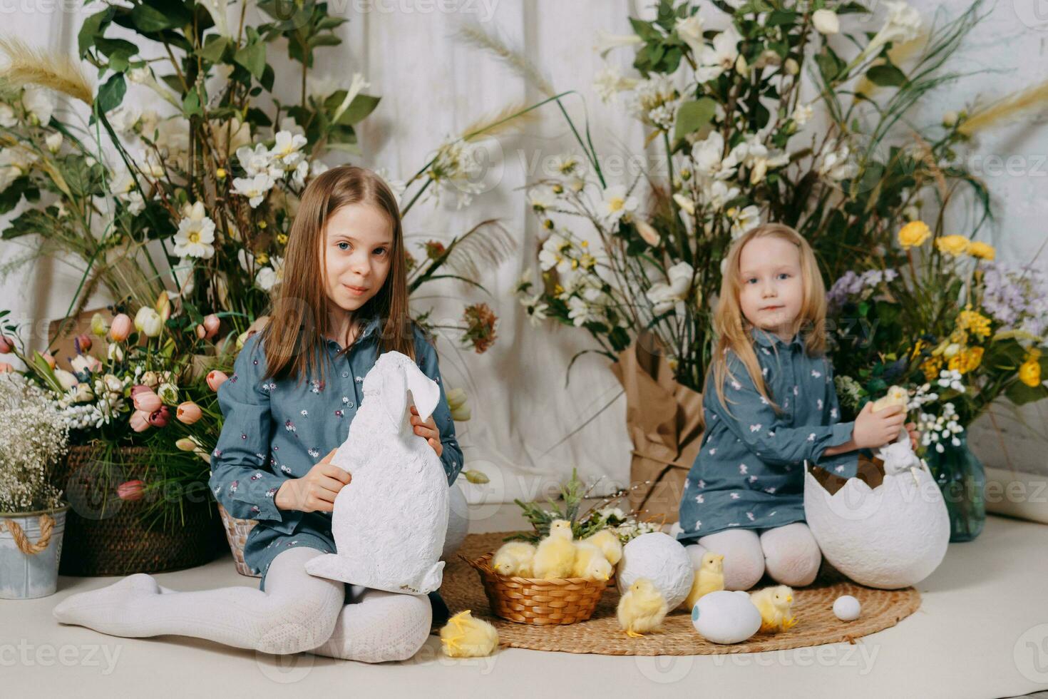 Due ragazze nel un' bellissimo Pasqua foto zona con fiori, uova, polli e Pasqua coniglietti. contento Pasqua vacanza.