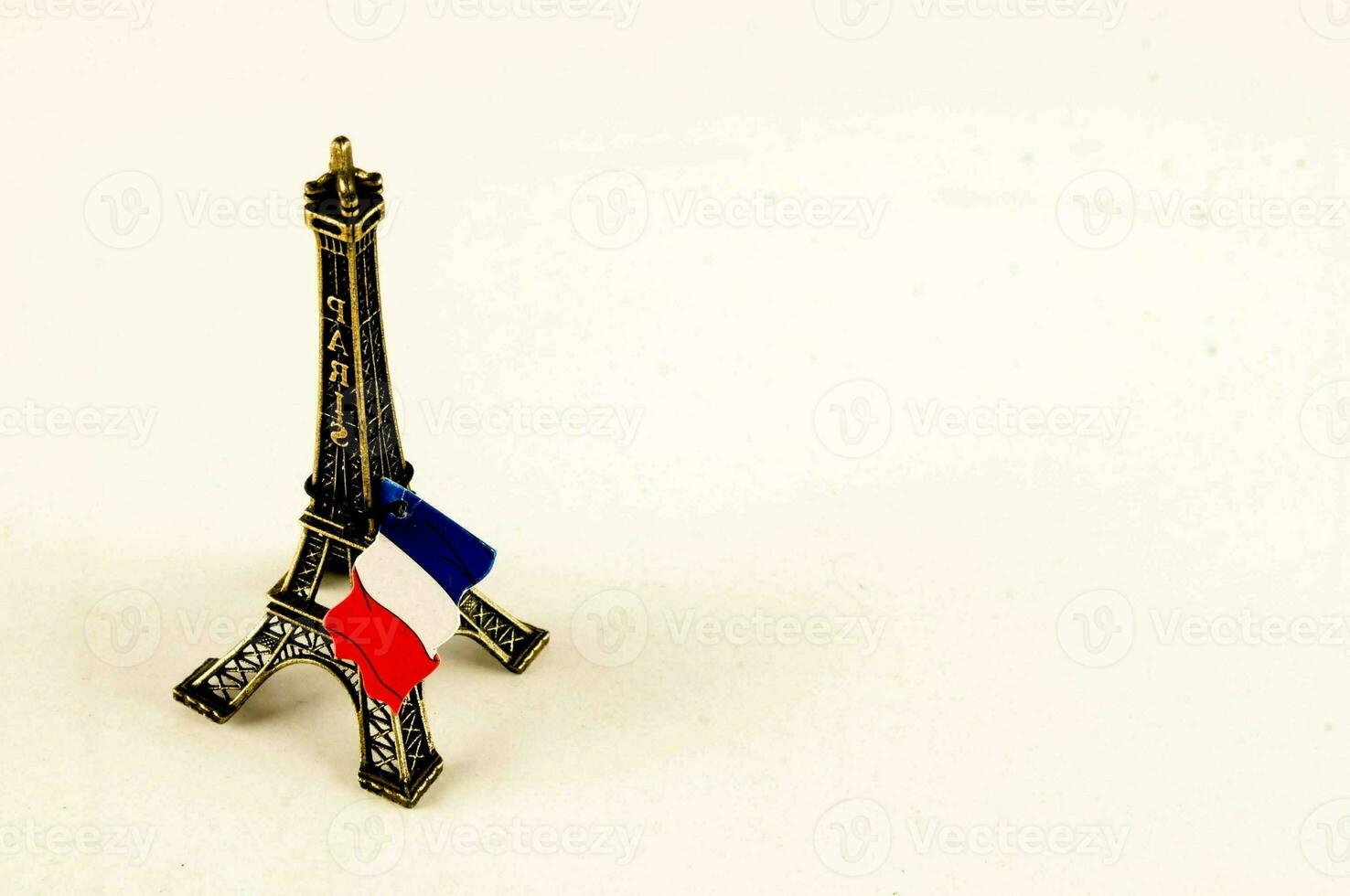 un' miniatura eiffel Torre con un' francese bandiera su superiore foto