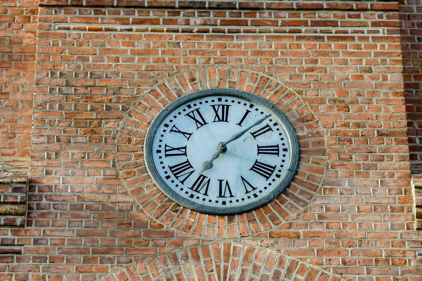 un' orologio su il lato di un' mattone edificio foto