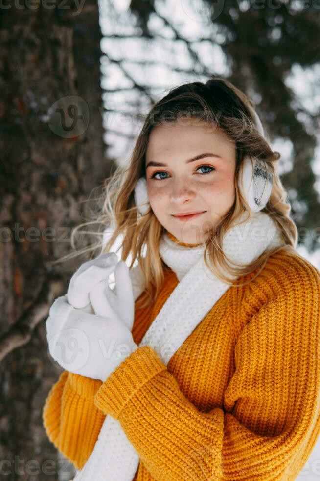 adolescente bionda nel un' giallo maglione al di fuori nel inverno. un' adolescenziale ragazza su un' camminare nel inverno Abiti nel un' nevoso foresta foto