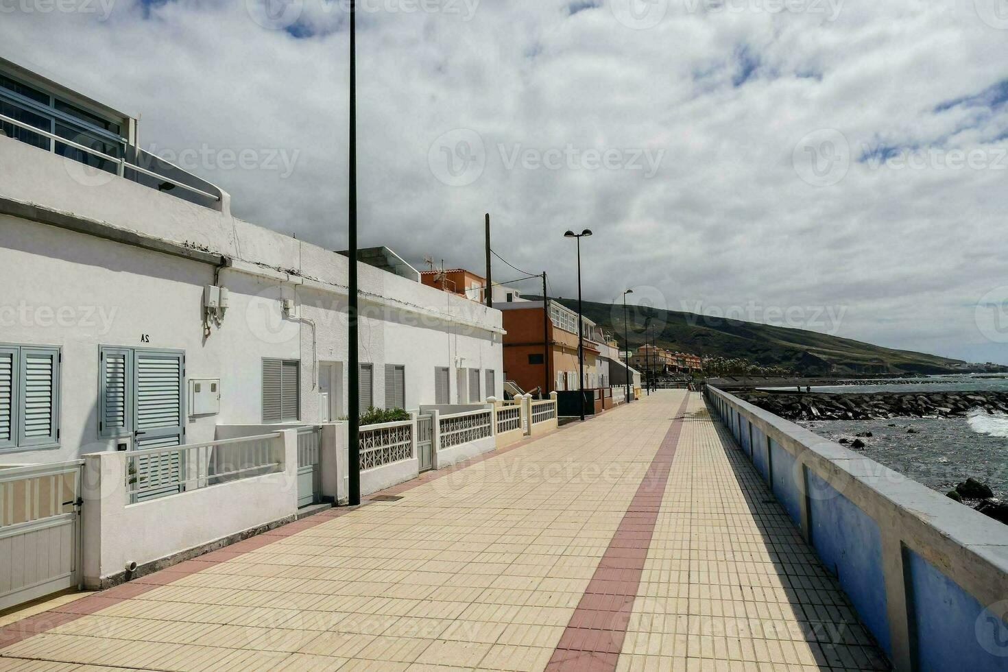 un' passerella lungo il spiaggia con case e un' edificio foto