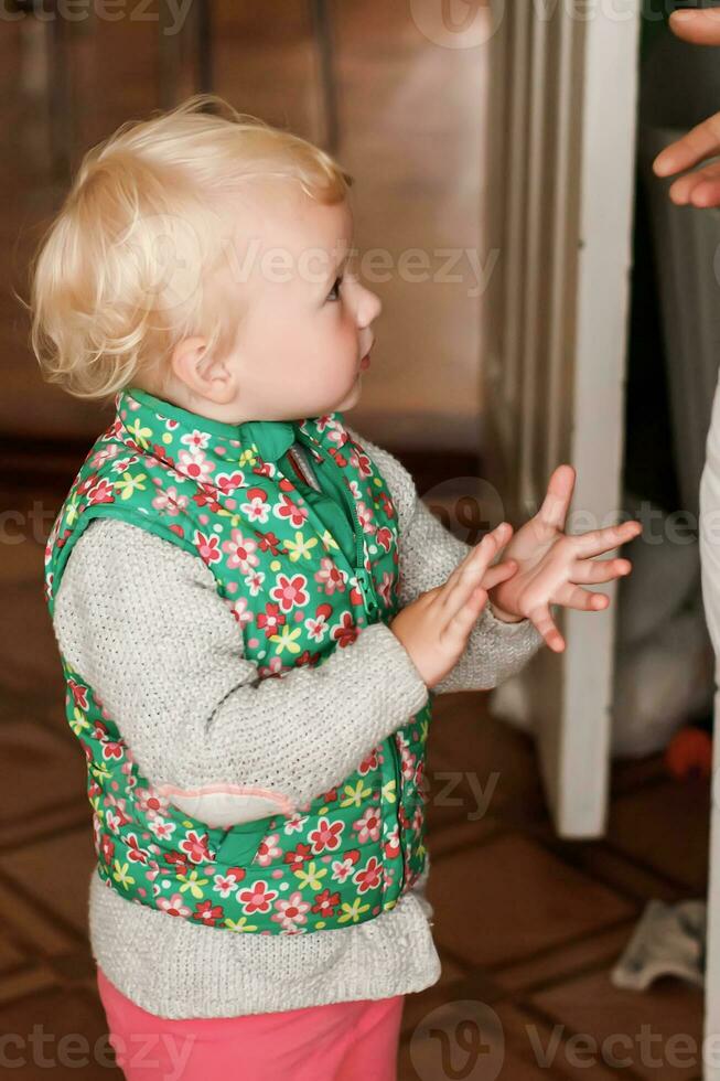 ragazza detiene sua dito su il palma di sua mano. bambino giochi dito Giochi a casa con genitori. Giochi per il sviluppo di bene il motore abilità. presto sviluppo di bambini. foto