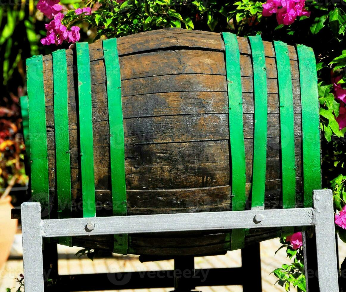 un' di legno barile con verde e viola fiori foto