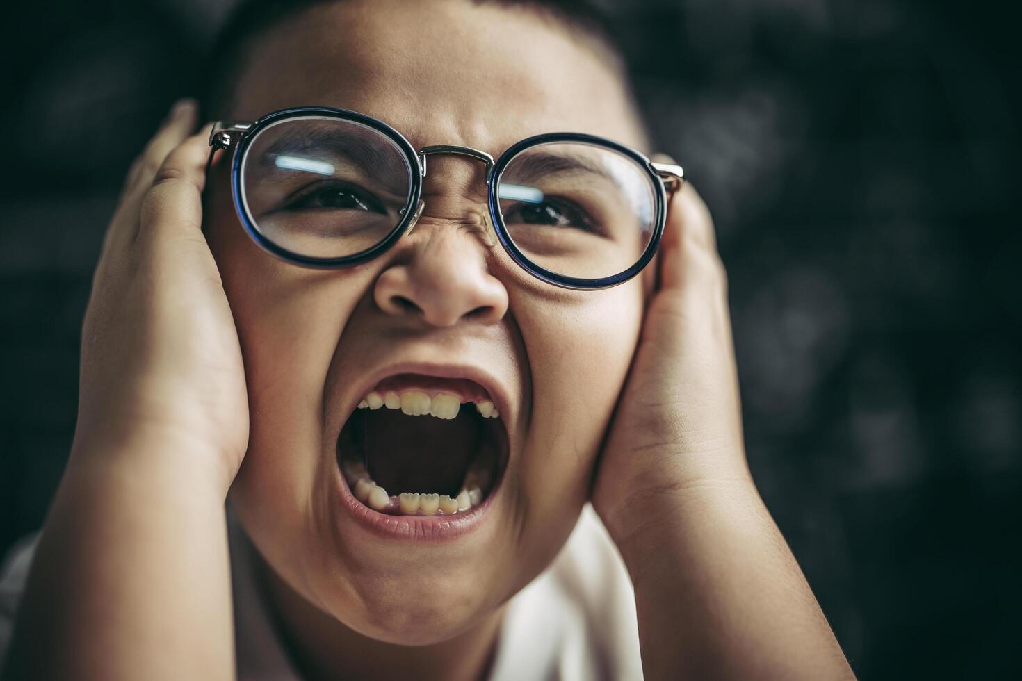 i ragazzi con gli occhiali scrivono libri e pensano in classe foto