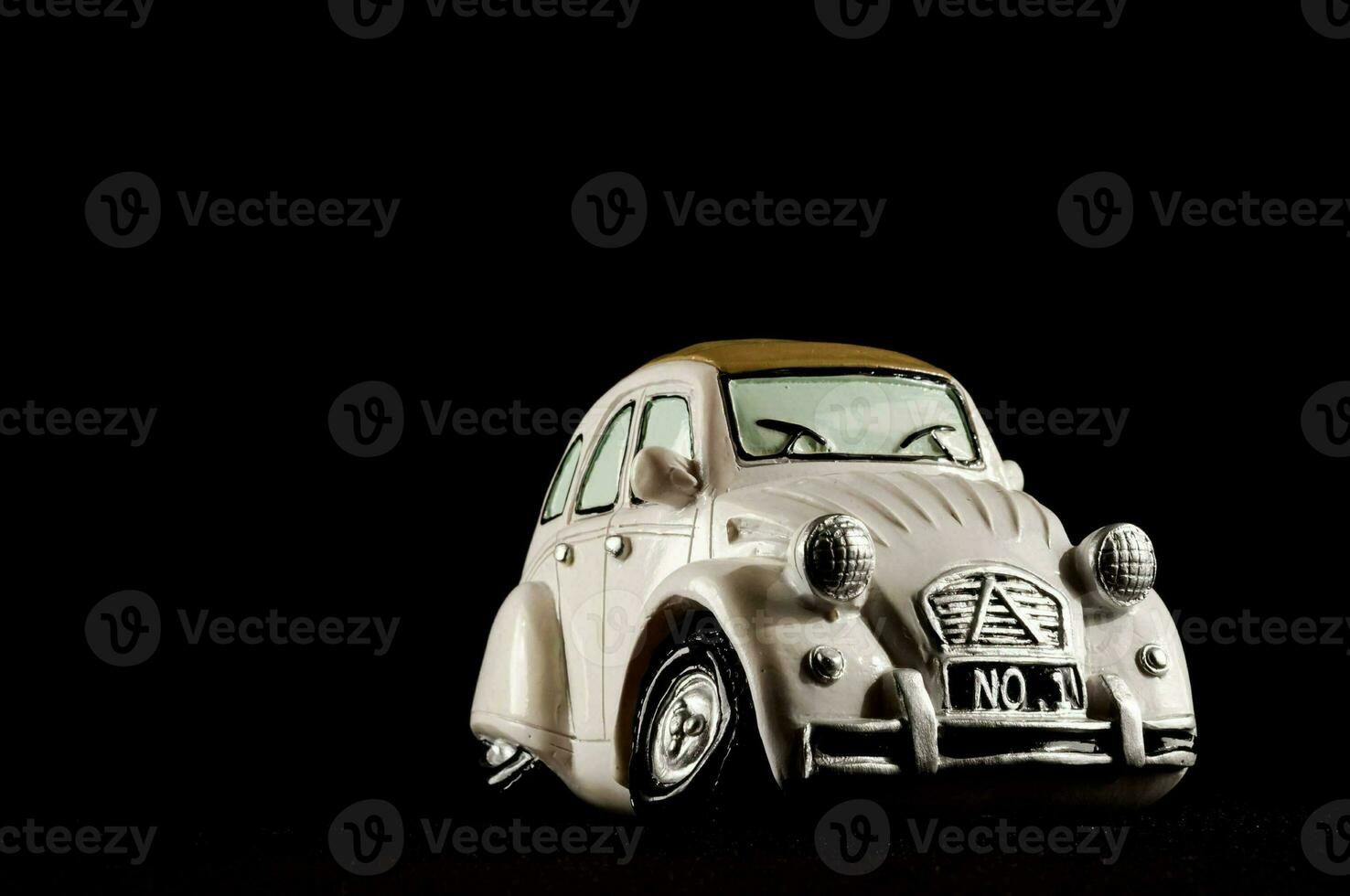 un' bianca giocattolo auto è mostrato contro un' nero sfondo foto