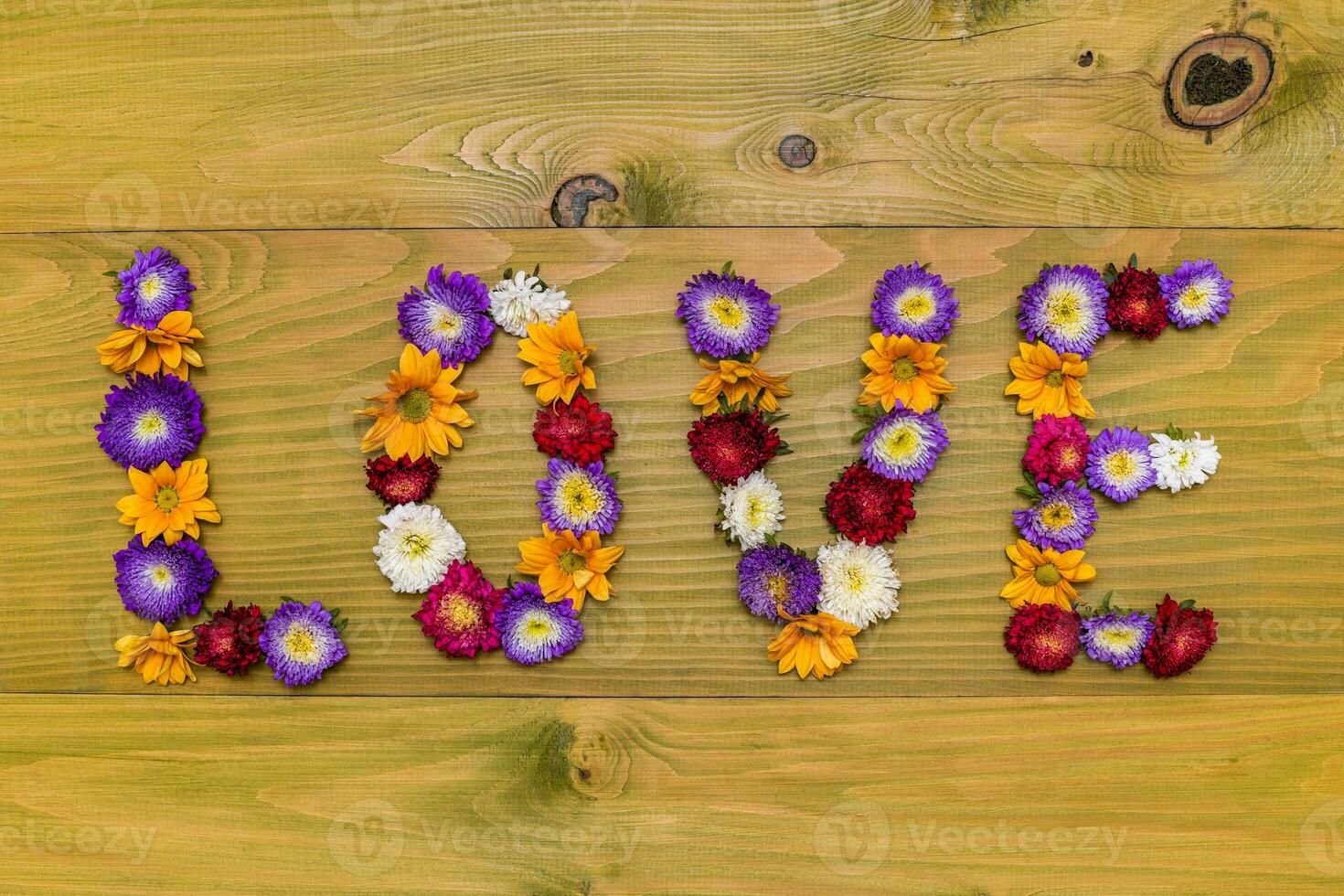 Immagine di parola amore fatto di bellissimo fiori su di legno sfondo foto