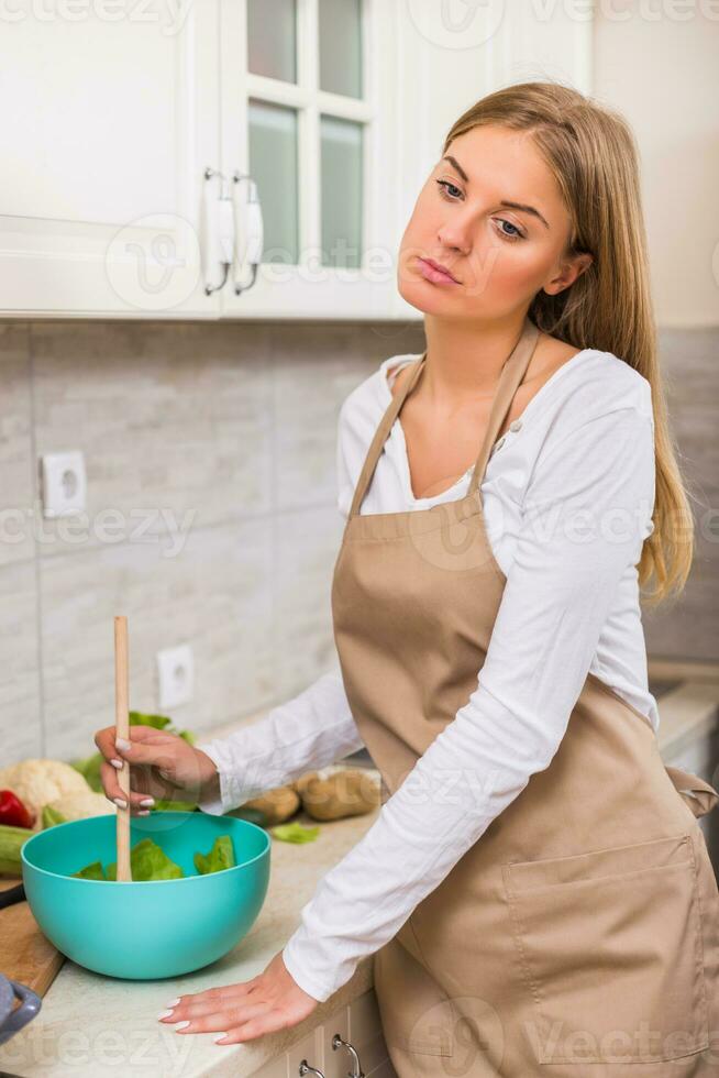 stanco casalinga fabbricazione pasto nel sua cucina foto