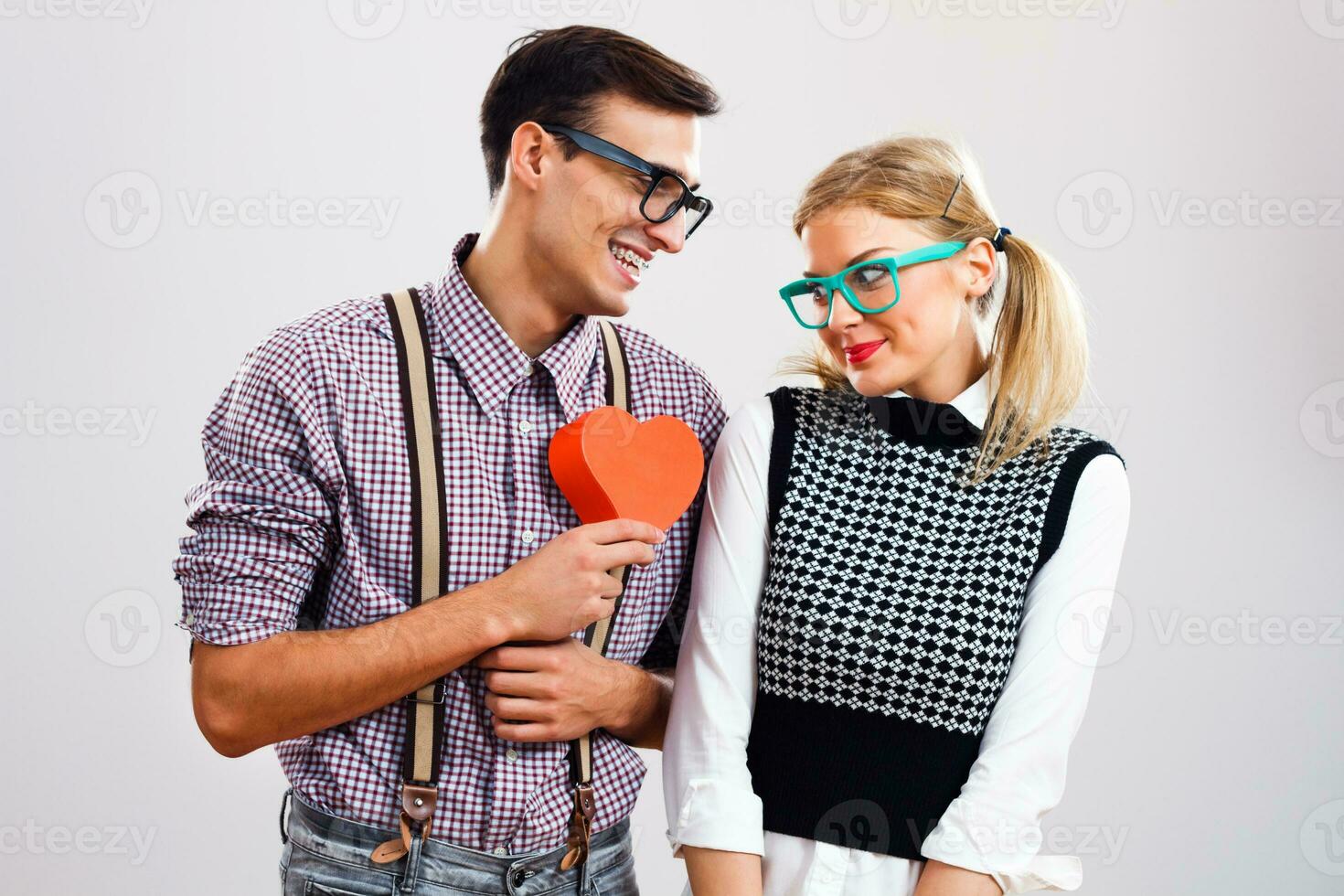 nerd uomo è dando cuore forma scatola per il suo nerd fidanzata foto