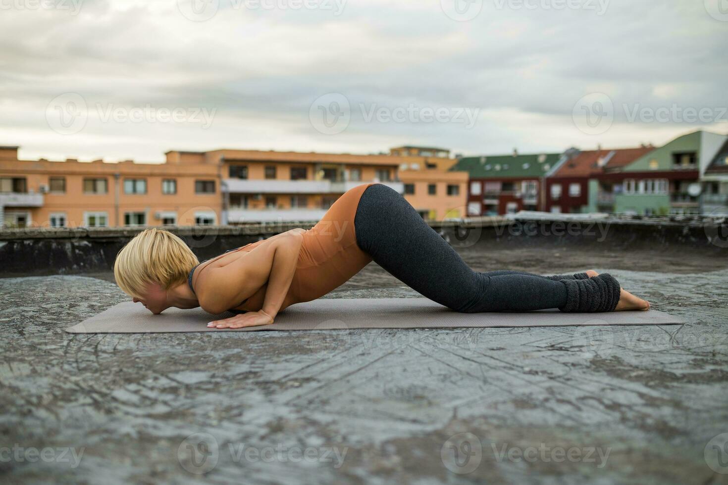 donna praticante yoga su il tetto foto