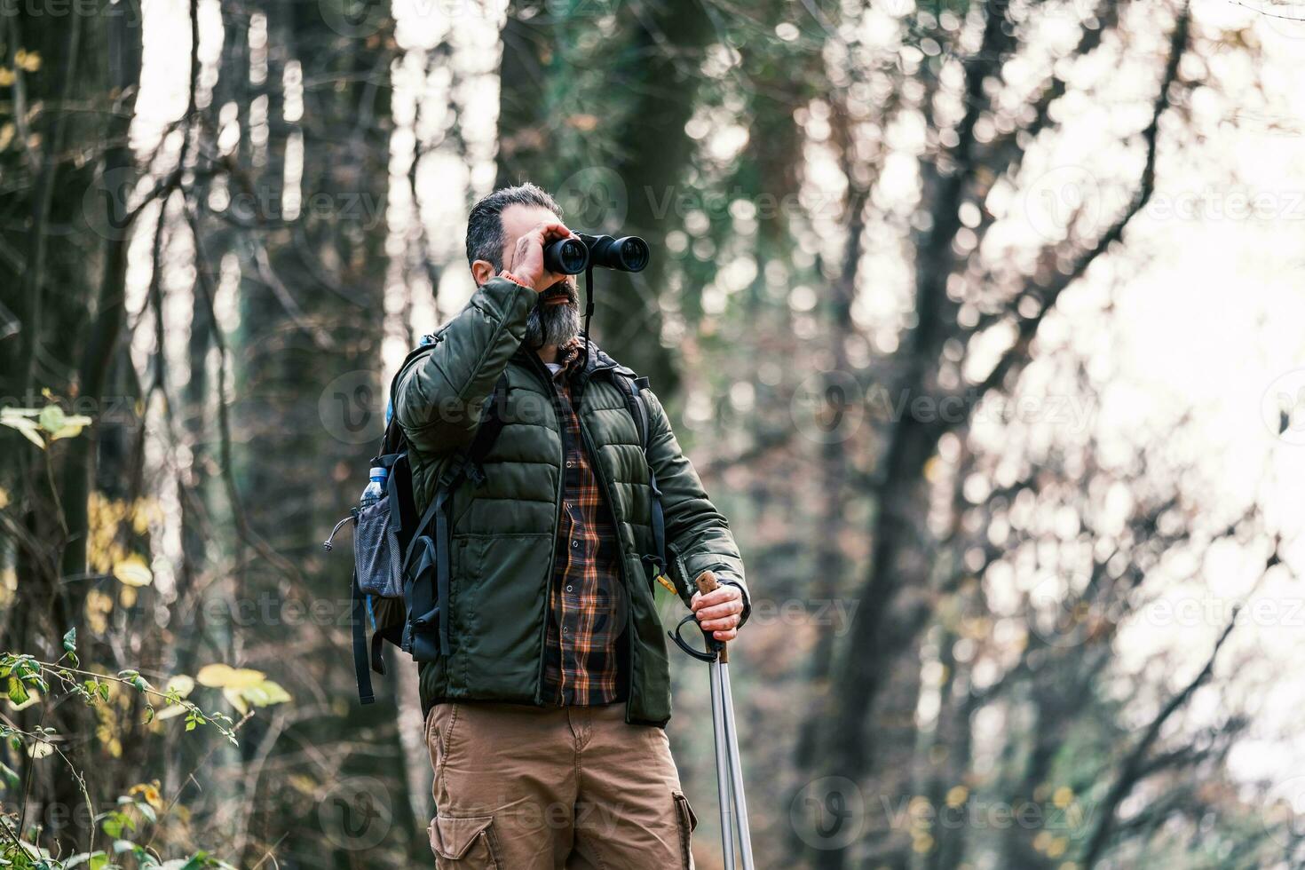 Immagine di uomo escursioni a piedi e utilizzando binocolo foto