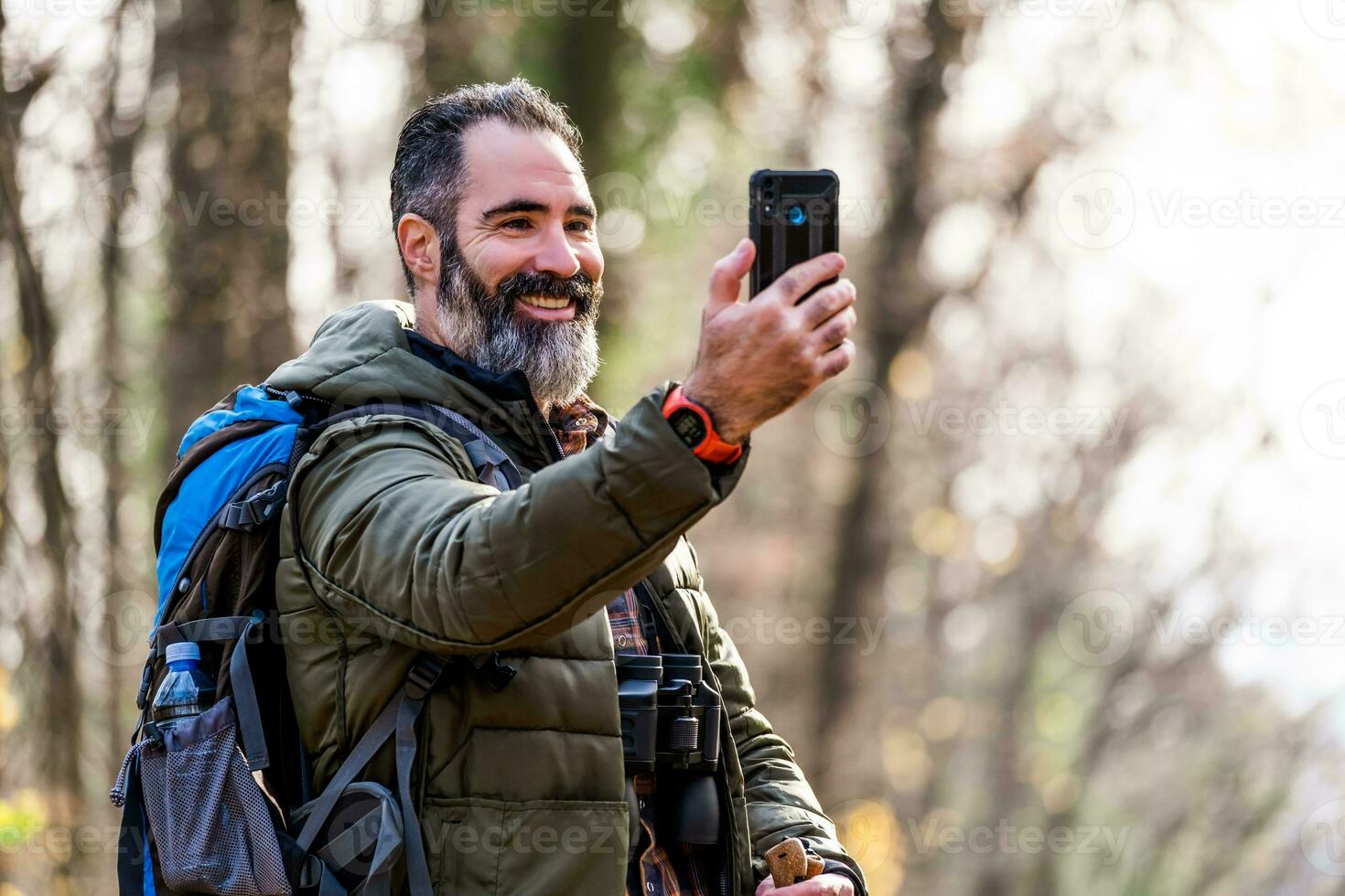 Immagine di uomo gode escursioni a piedi e fabbricazione autoscatto con il suo Telefono foto