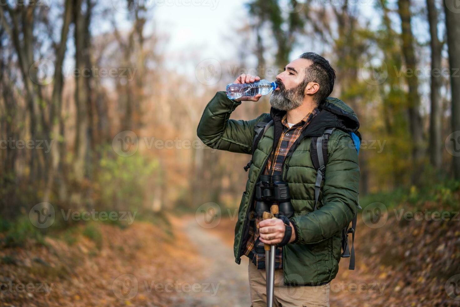 Immagine di uomo potabile acqua mentre escursioni a piedi foto