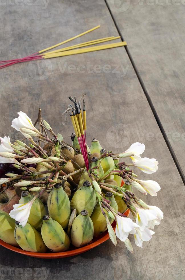 ciotola per offerte buddista con dettagli di frutta e fiori di incenso foto