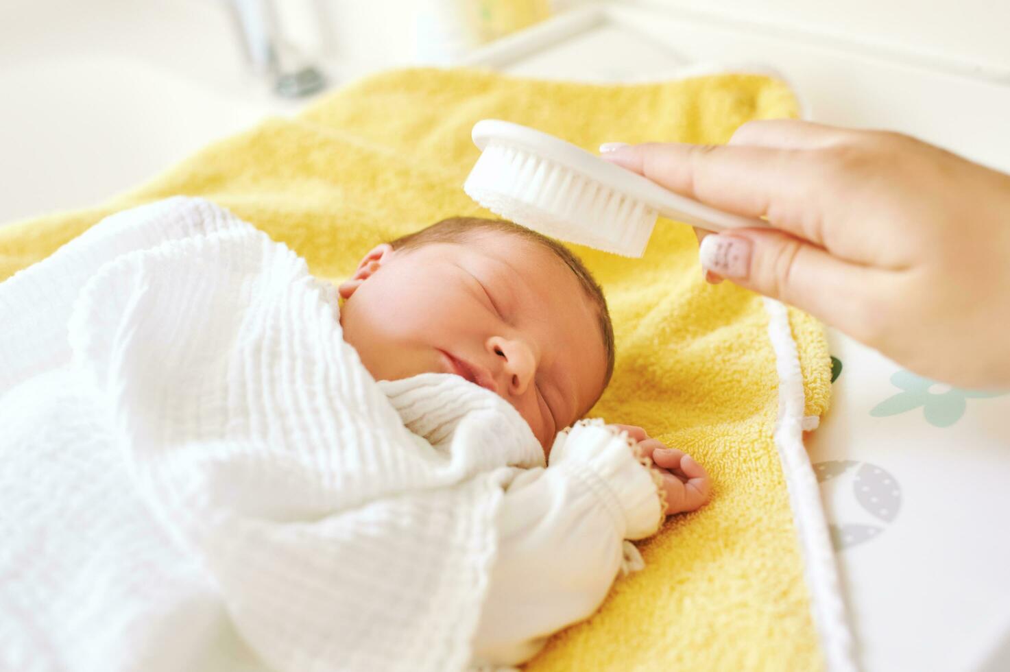 madre spazzolatura capelli di addormentato neonato bambino foto