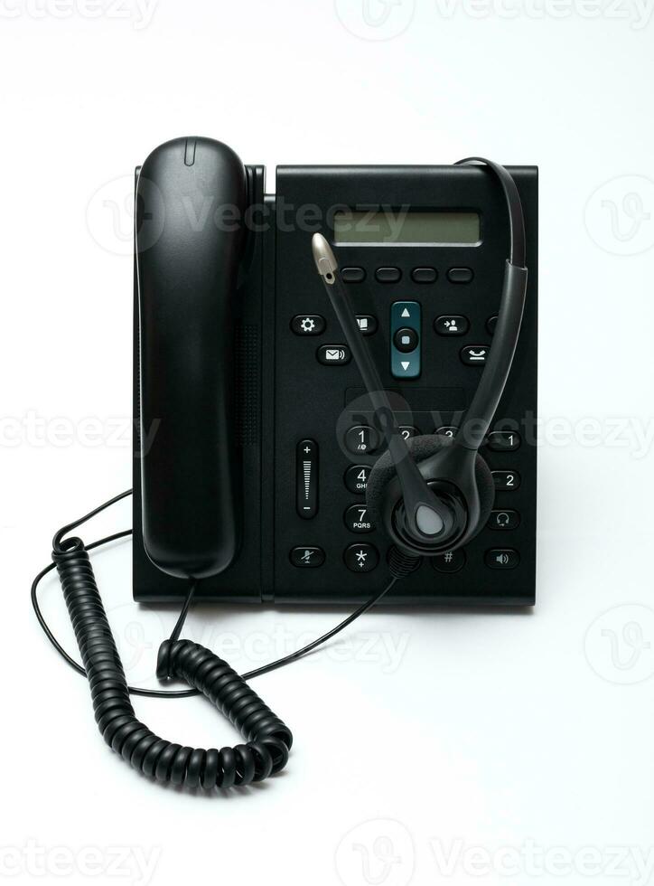 nero del desktop Telefono con un' cuffia su il bianca sfondo foto