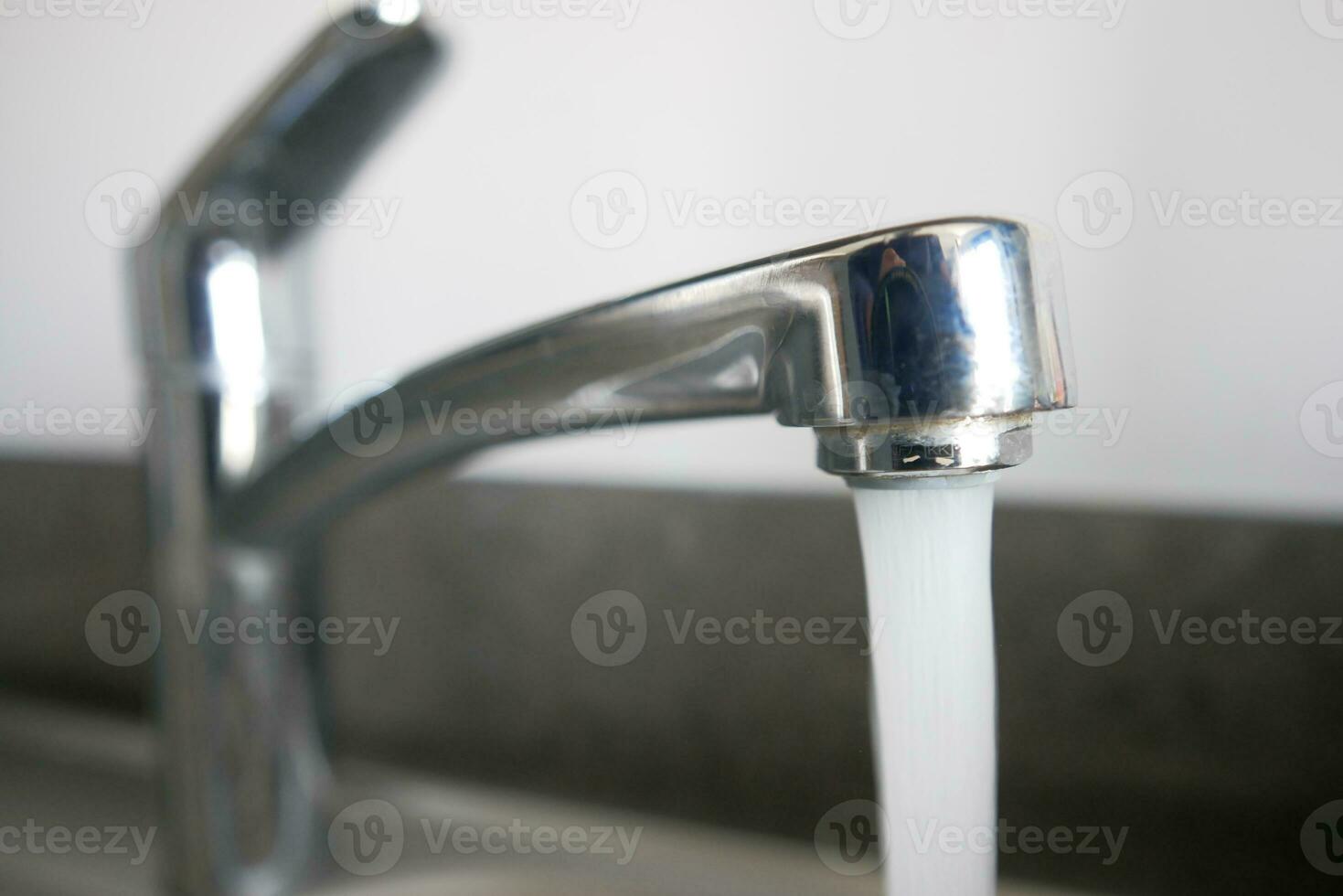 acqua scrosciante a partire dal un' rubinetto rubinetto lento movimento foto