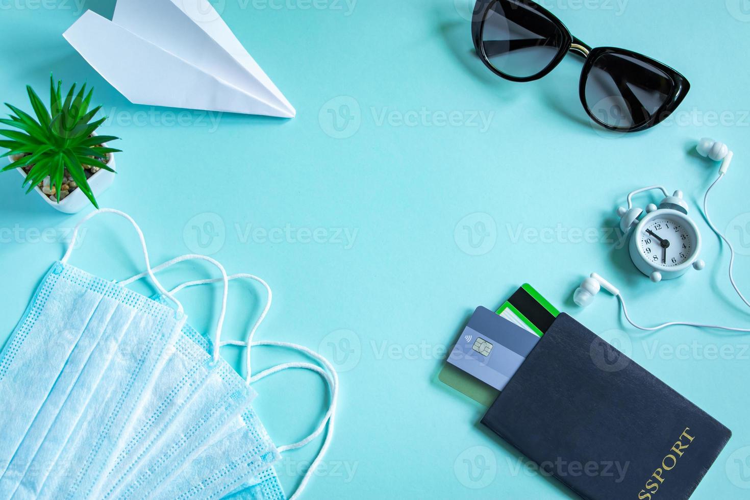 concetto di viaggio sicuro durante la pandemia di coronavirus. passaporto, maschera medica e occhiali da sole su sfondo blu. foto