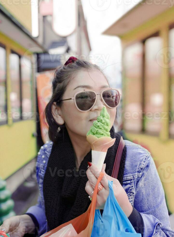 asiatico donna mangiare verde tè gelato a otaru strada hokkaido Giappone ,otaru è uno di maggior parte popolare in viaggio destinazione foto