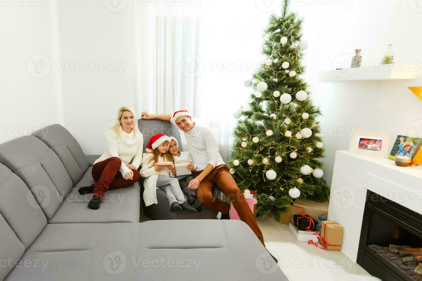 contento famiglia padre madre e bambini seduta di camino su Natale vigilia foto