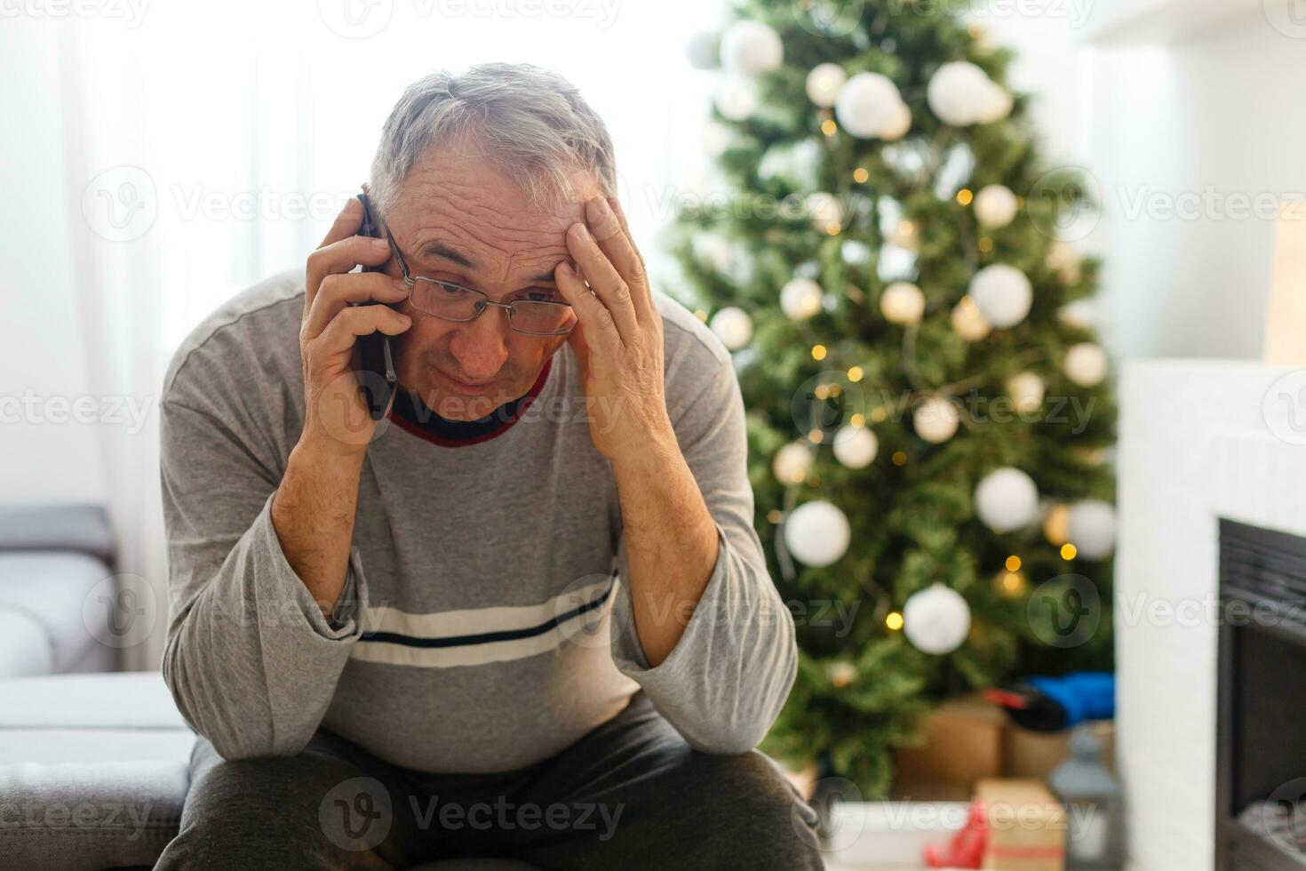 Natale, vacanze e persone concetto - contento sorridente anziano anziano uomo seduta con smartphone a Natale a casa foto