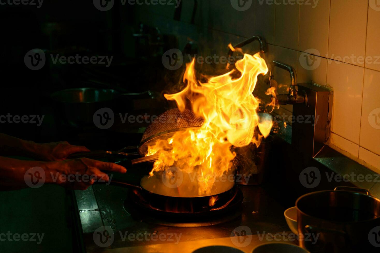 capocuoco cucinando e fare fiamma su cibo nel ristorante cucina foto