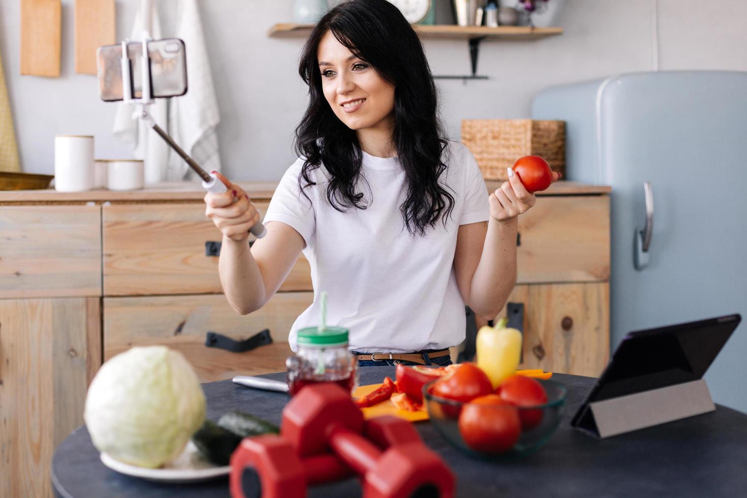 ragazza carina e magra che si fa i selfie mentre cucina foto