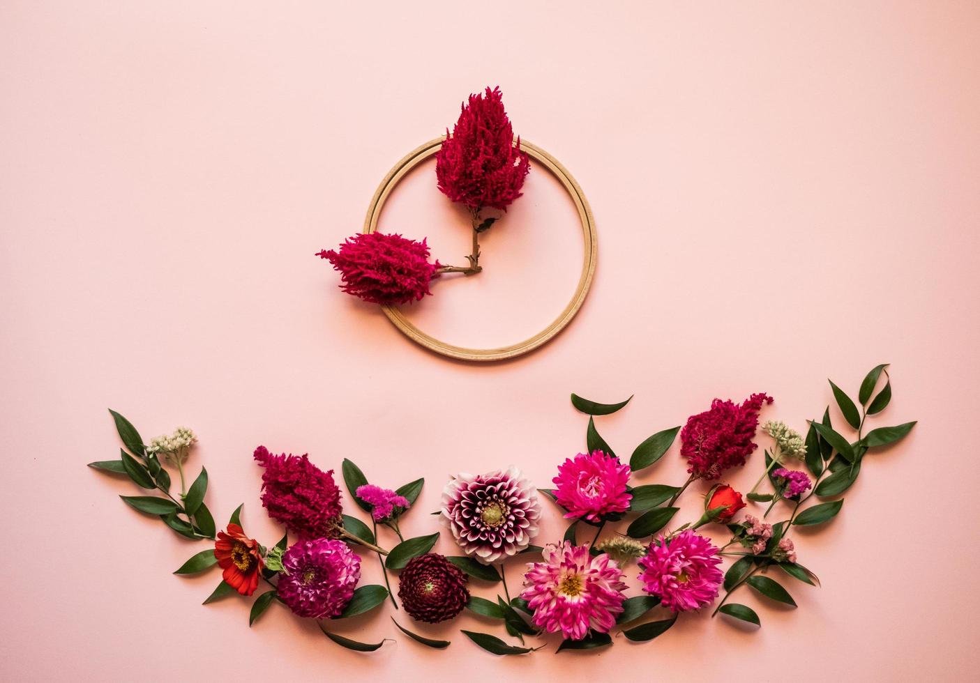 i fiori freschi giacciono su uno sfondo rosa - a forma di orologio foto