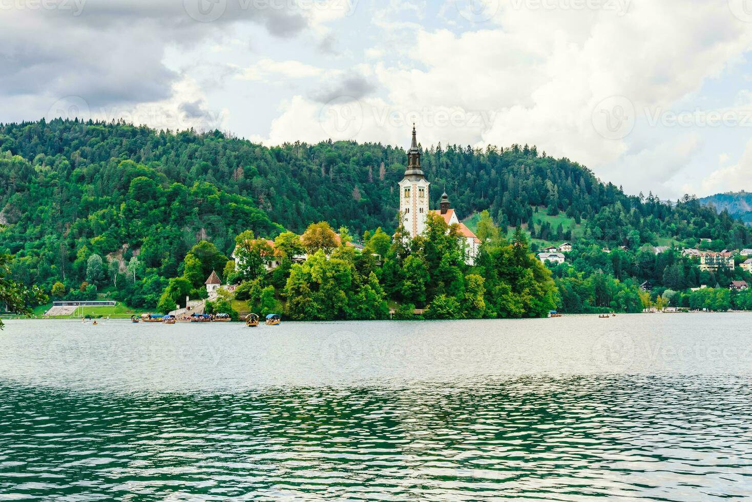 antico Chiesa nel il mezzo di il lago circondato di colorato alberi foto