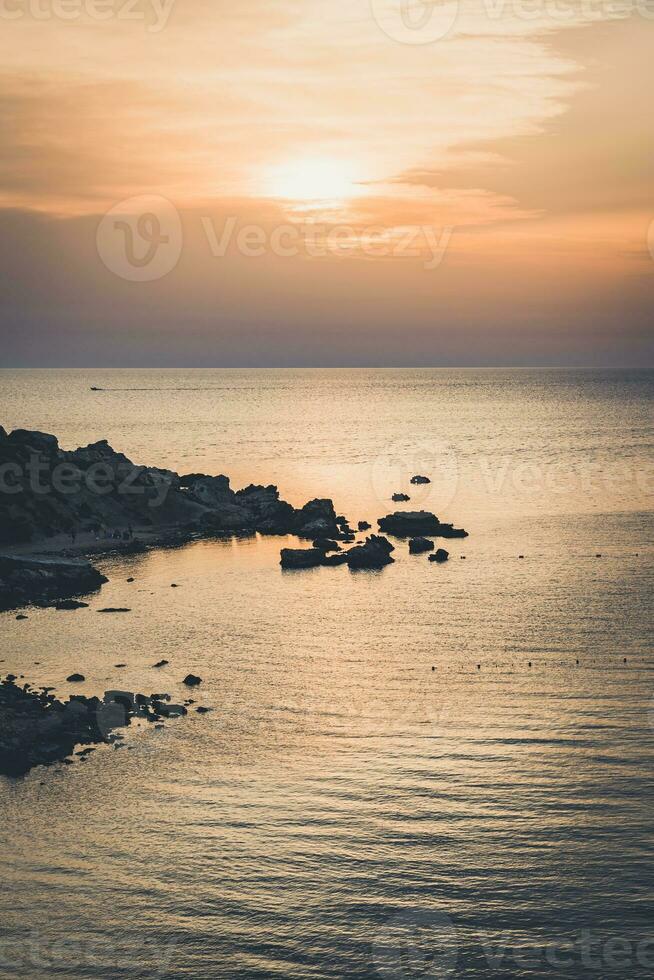 spettacolare tramonto nel il sera nel baia la zona con sole raggi riflettendo nel acqua foto