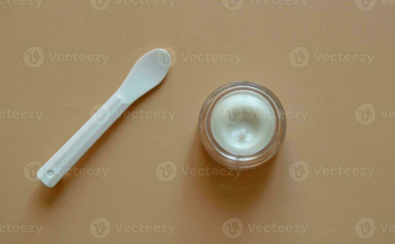 plastica vaso di bellezza crema o maschera per viso cura con spatola su pastello sfondo, superiore Visualizza. concetto di cura della pelle cosmetici, cosmetico terme medico pelle cura. naturale cosmetici concetto. foto