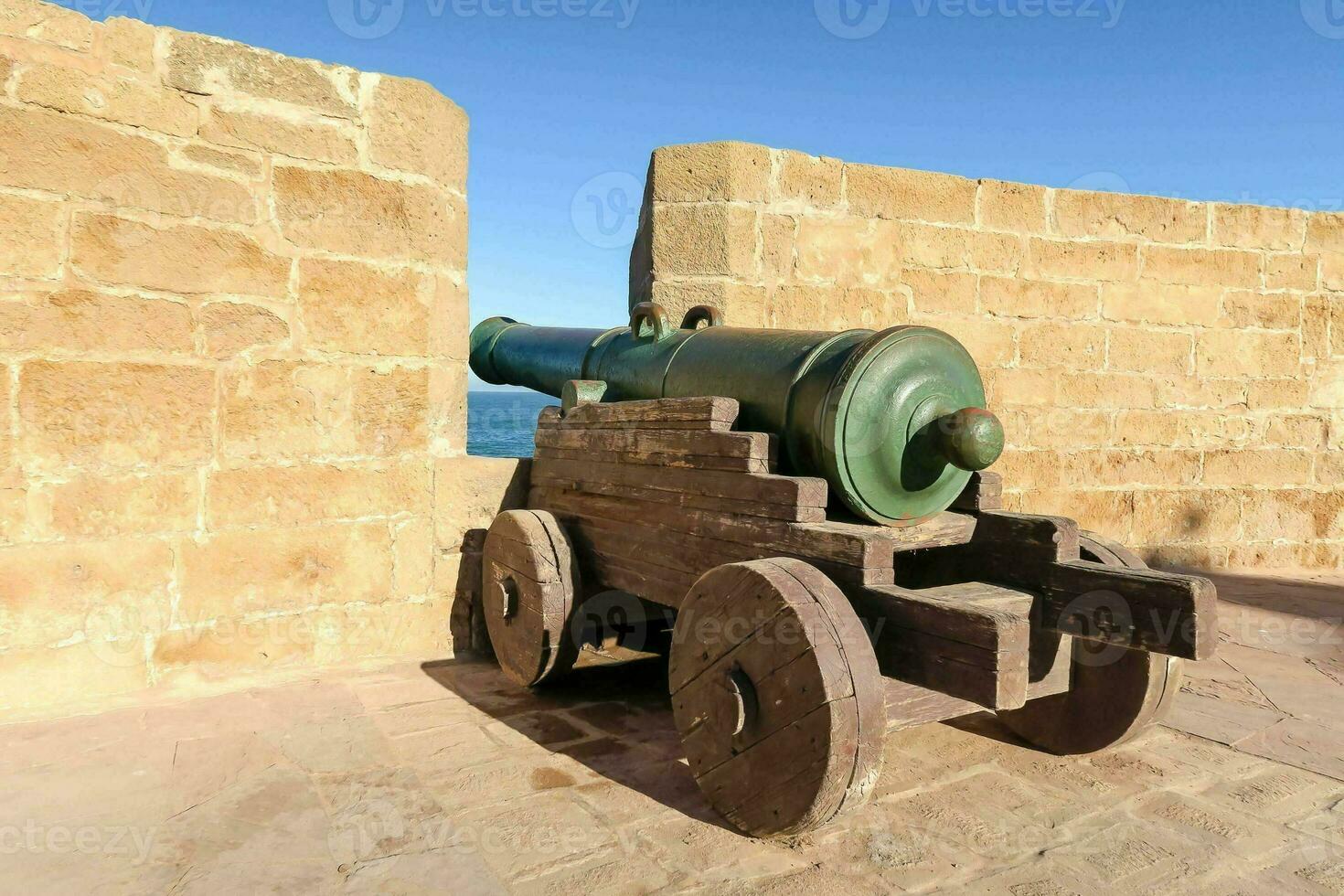 un' cannone su un' pietra parete vicino il oceano foto