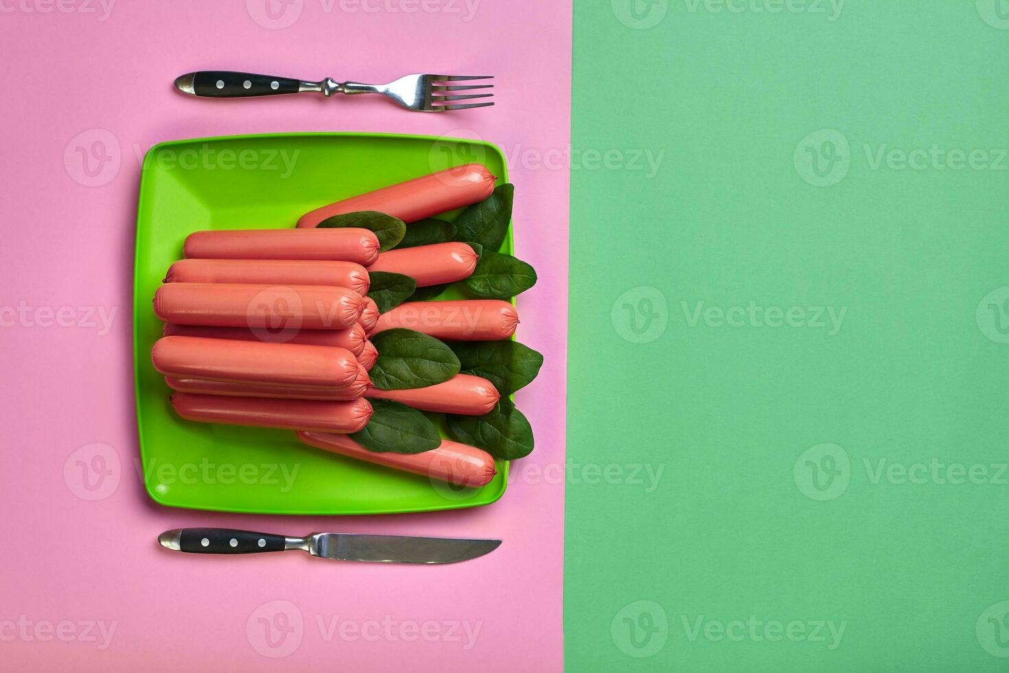 salsicce su un' verde e rosa minimo sfondo. piatto posizione. superiore Visualizza. foto