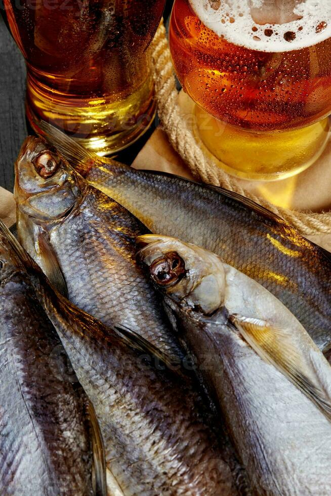 avvicinamento di salato asciugato ad aria scarafaggio pesce, pesce sciabola e pertica servito con ambra birra foto