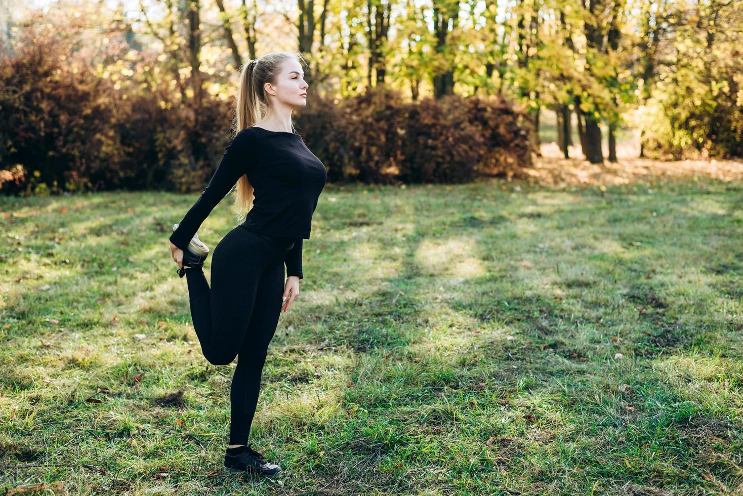 ragazza snella in abbigliamento sportivo che si scalda all'aria aperta foto