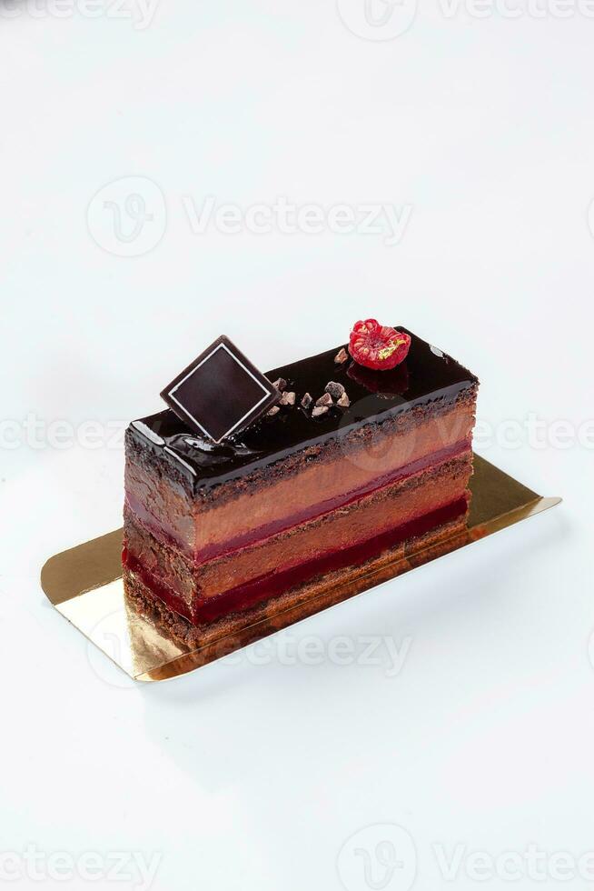 spugna torta fetta con cacao mousse, gelatina lampone marmellata sormontato con cioccolato glassatura foto