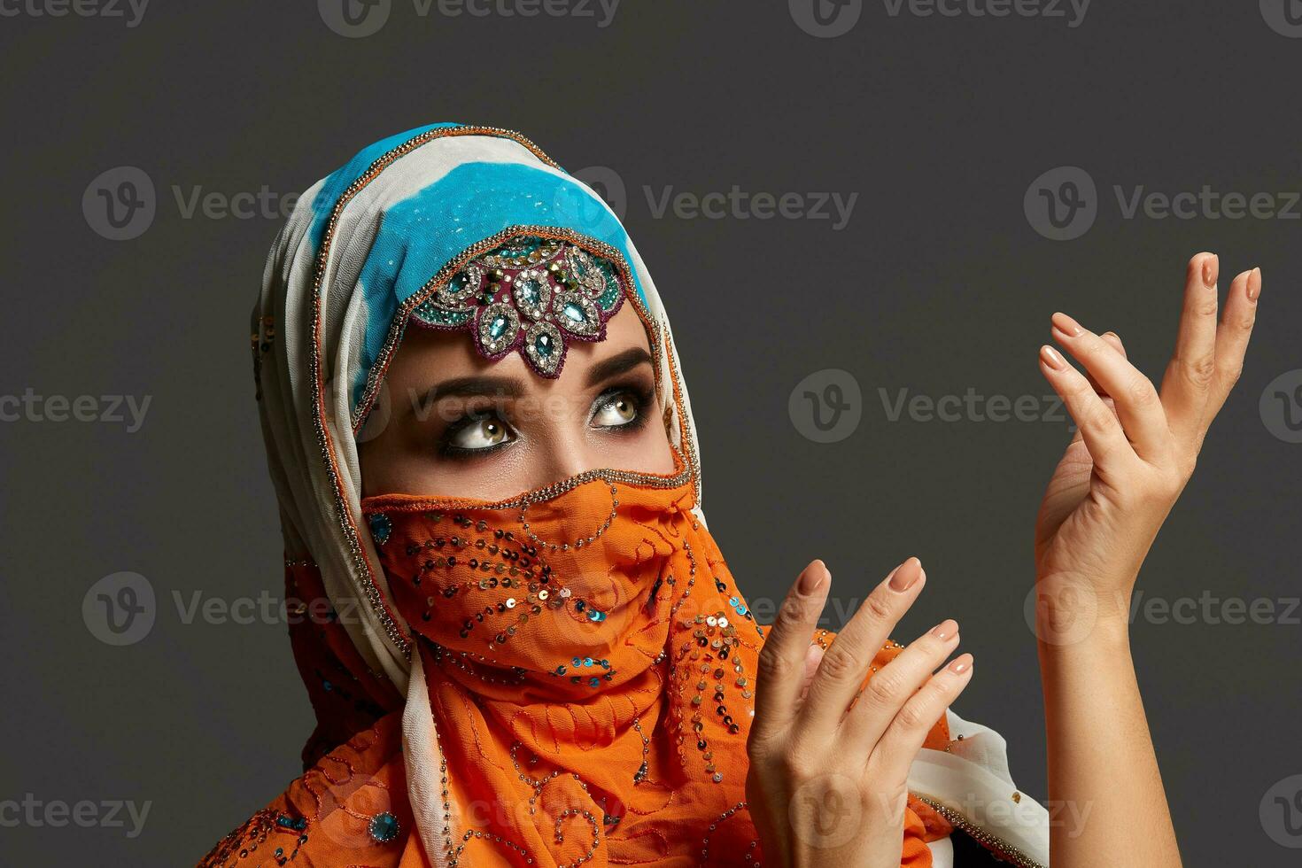 studio tiro di un' affascinante femmina indossare il colorato hijab decorato con paillettes e gioielleria. Arabo stile. foto