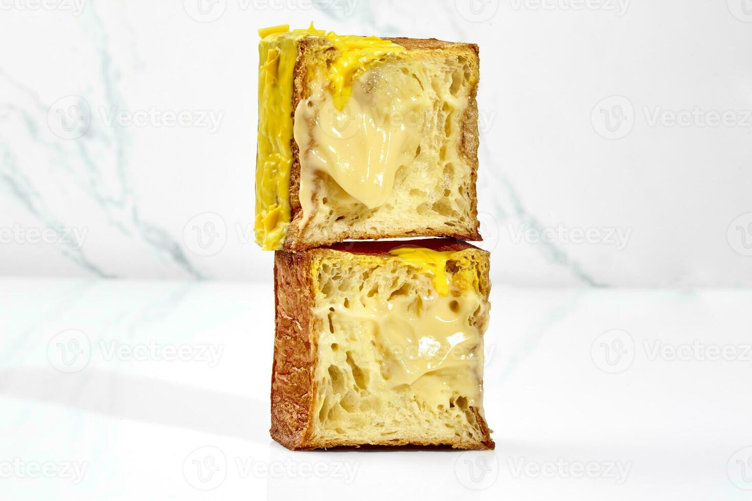 affettato fragili cubo brioche con vaniglia crema pasticciera Riempimento, giallo Smalto e cioccolato patatine fritte foto