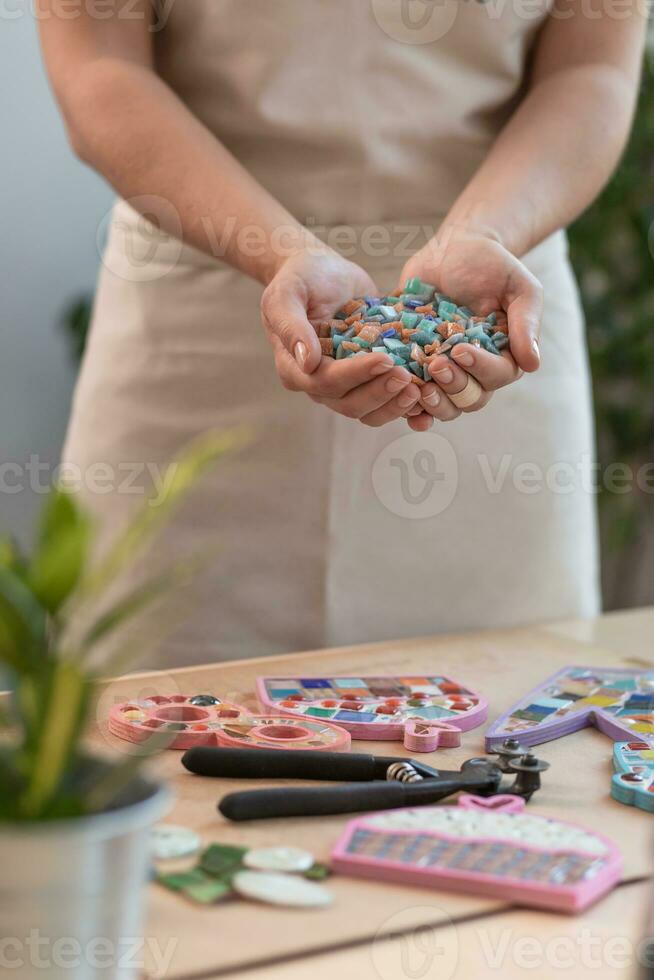 posto di lavoro di il mosaico maestro Da donna mani Tenere mosaico dettagli nel il processi di fabbricazione un' mosaico foto