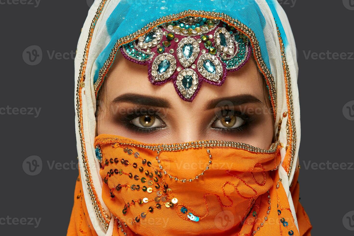 studio tiro di un' affascinante femmina indossare il colorato hijab decorato con paillettes e gioielleria. Arabo stile. foto