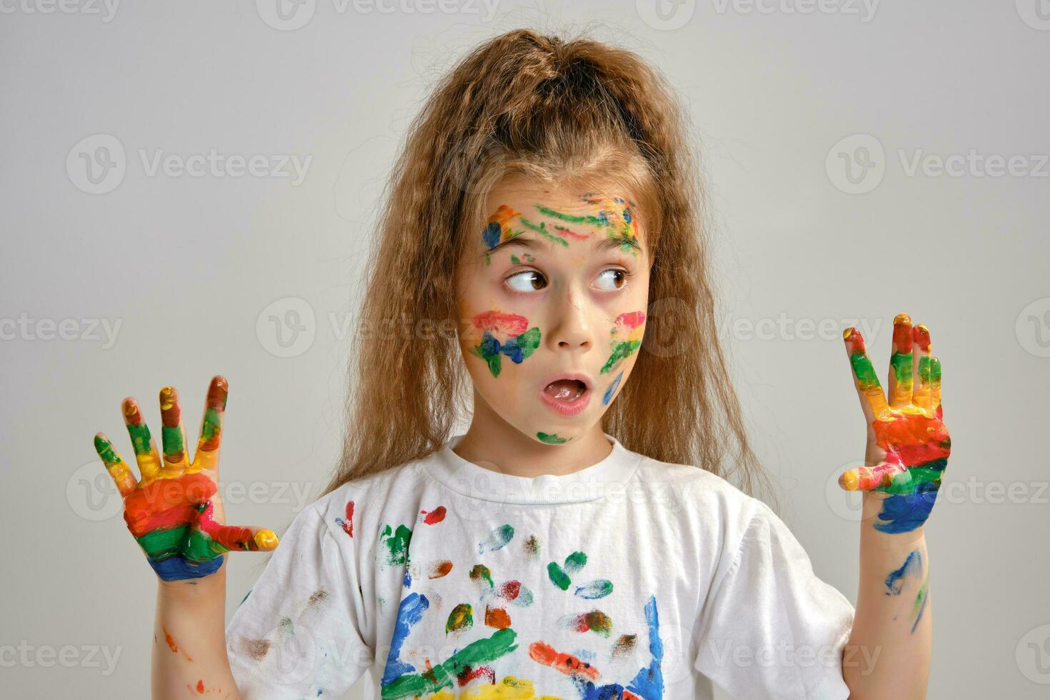 poco ragazza nel bianca maglietta è in posa in piedi isolato su bianca e gesticolando con sua dipinto nel diverso colori palme. arte studio. avvicinamento. foto